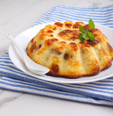 Cottage cheese casserole decorated with mint on a marble background