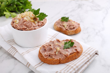 Bean paste with fried onions in a white ceramic form on a marble background.