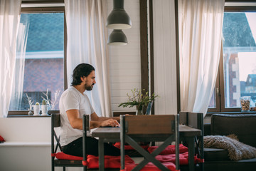 Workplace at home. A man works at a laptop at home