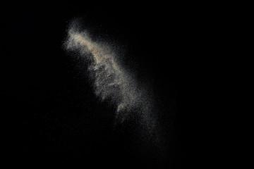 Sandy explosion isolated on black background. Abstract particles cloud. Texture element for design.
