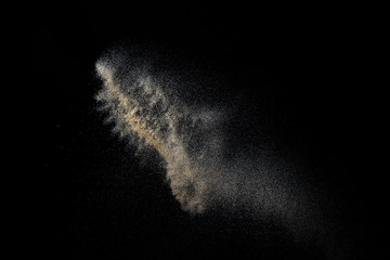 Sandy explosion isolated on black background. Abstract particles cloud. Texture element for design.