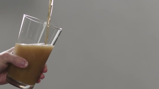 Slow motion man pour nitro beer in pint glass