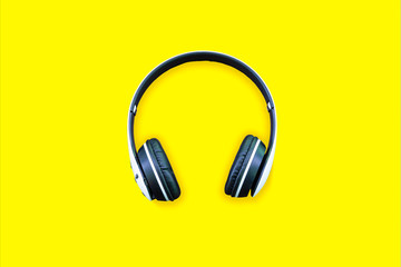Minimalistic top view composition with white headphones on bright yellow background with a lot of copy space for your text. Close up, flat lay.