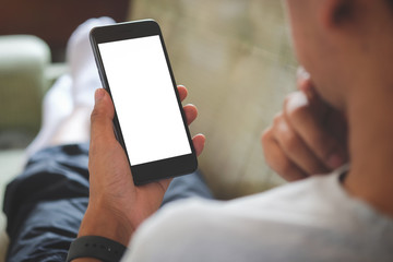 Cropped shot view of man hands holding smart phone with blank copy space screen for your text message or information content, female reading text message on cell telephone during in urban setting.