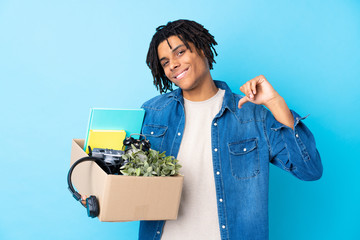 Young African American man making a move while picking up a box full of things proud and...