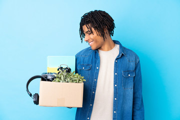 Young African American man making a move while picking up a box full of things with happy expression