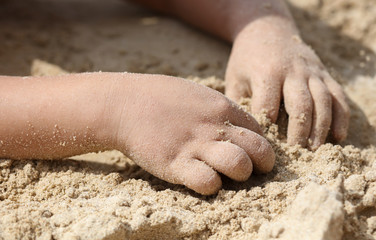 A boy is playing in the sand of a beach.