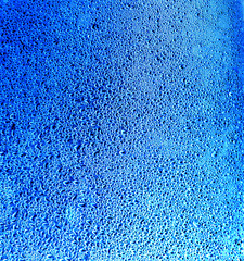 Fototapeta na wymiar Drops of water on blue glass as an abstract background