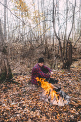 A man sitting near the campfire and enjoy the atmosphere.