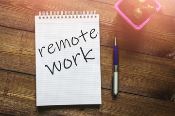 The phrase "Remote work" in the notebook next to a cactus and a pen on a dark wooden background. The concept of quarantine