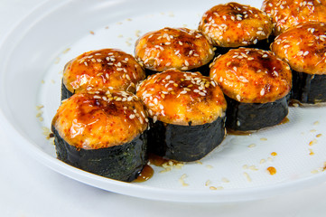 Japanese roll with rice poured with syrup and powdered sesame seeds