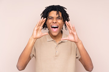 Young African American man over isolated background shouting with mouth wide open