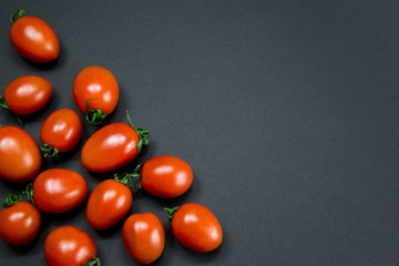 Red ripe tomatoes on black background. Top view with copy space