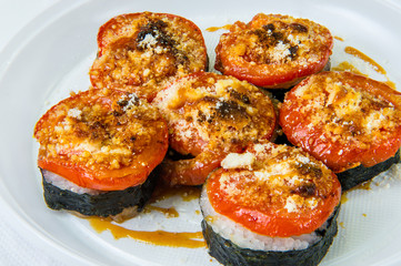 Traditional rice Japanese rolls covered with fried tomato and cheese. Lie on a plastic disposable plate