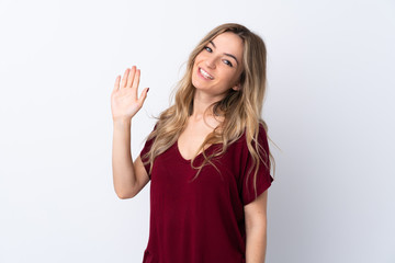 Obraz na płótnie Canvas Young woman over isolated white background saluting with hand with happy expression