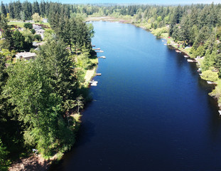Obraz premium Lovely Lake Holm Water Access Site in springtime with the surrounding forest and homes and the sky and clouds in Auburn Washington