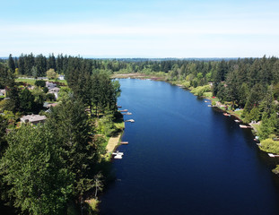 Lovely Lake Holm Water Access Site in springtime with the surrounding forest and homes and the sky and clouds in Auburn Washington