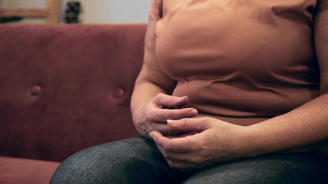 Senior woman suffering from Parkinson syndrome at home