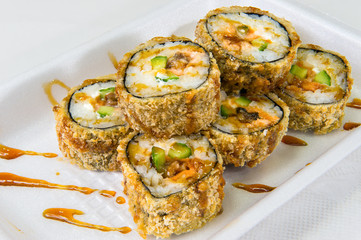 Traditional rolls with eel, cucumbers, carrots, rice and seaweed breaded on a disposable plastic plate