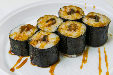 Japanese rolls with rice and eel sprinkled with soy sauce