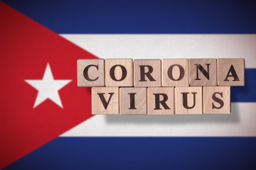 Flag of Cuba with wooden cubes spelling coronavirus on it. 2019 - 2020 Novel Coronavirus (2019-nCoV) concept, for an outbreak occurs in Cuba.