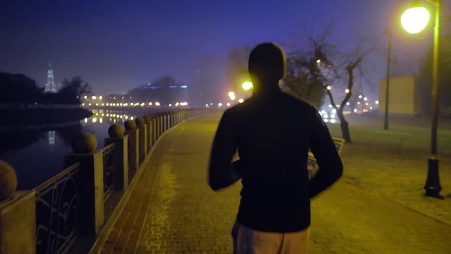 man running on the street at night city