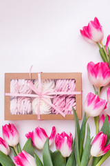 A box with homemade marshmallows and a bouquet of Tulip flowers on a white background. Space for text