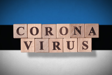 Obraz premium Flag of Estonia with wooden cubes spelling coronavirus on it. 2019 - 2020 Novel Coronavirus (2019-nCoV) concept, for an outbreak occurs in Estonia.