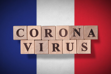 Flag of France with wooden cubes spelling coronavirus on it. 2019 - 2020 Novel Coronavirus (2019-nCoV) concept, for an outbreak occurs in France.