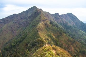 Naklejka premium view of mountains with hiker in background