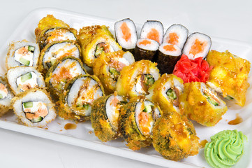 Set of four types of Japanese rolls and sushi with salmon, cucumber, cheese, rice, seaweed and wasabi with ginger