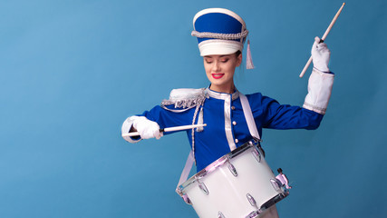 drummer in a blue uniform drums on a drum, show program and celebration.