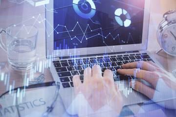 Multi exposure of market chart with man working on computer on background. Concept of financial analysis.