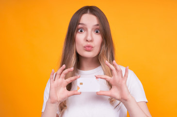 Young emotional sweet girl with bank credit card.