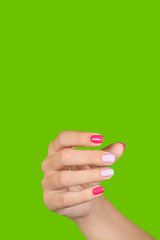 Vertical color photography of manicured female hand isolated on bright green background. Woman making gesture with her five fingers as if holding something virtual and invisible.