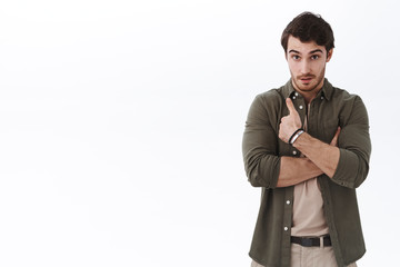 Surpirsed man pointing himself and stare confused camera, hear his name mentioned, shocked boss picked him, standing questioned raise eyebrows and looking indecisive, white background
