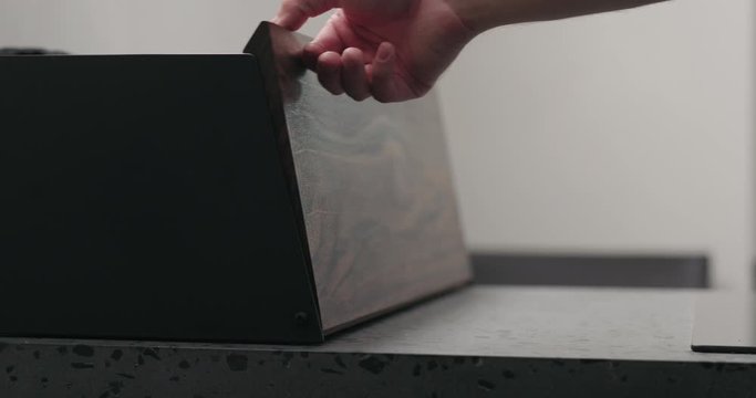 Slow motion man hand check walnut wood breadbox