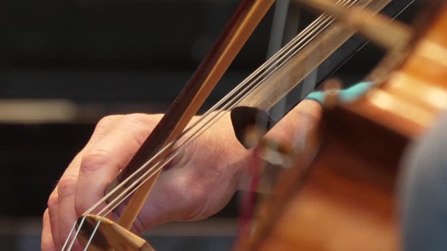 cellist playing cello in orchestra