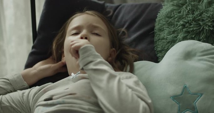 chora dziewczynka kaszle i ma gorączkę, mama mierzy jej temperaturę.