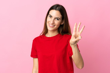 Young caucasian woman isolated on pink background happy and counting three with fingers