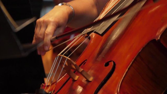 cellist playing cello in orchestra
