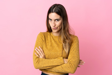Fototapeta premium Young caucasian woman isolated on pink background with unhappy expression