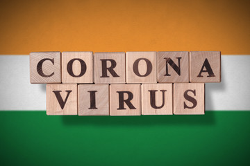 Flag of India with wooden cubes spelling coronavirus on it. 2019 - 2020 Novel Coronavirus (2019-nCoV) concept, for an outbreak occurs in India.