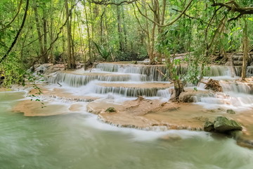 Obraz premium Beautiful soft silky white water flowing on arch rock with green forest background, Huay Mae Khamin Waterfall floor 6th (Dong Pee Sua) Kanchanaburi, west of Thailand.