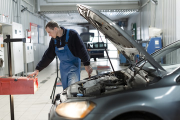 Car dealer service, auto mechanic checking of the headlights with a headlight tester device