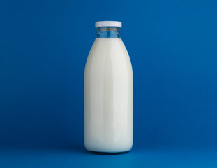 Glass milk bottle mock up on blue background