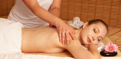Obraz na płótnie Canvas Beautiful young woman having a massage treatment in spa salon - wellness