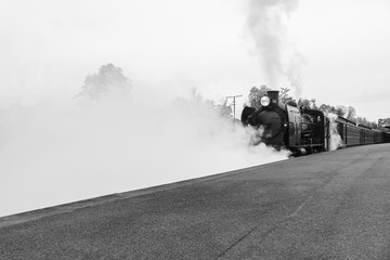 Fototapeta na wymiar CASTLEMAINE, AUSTRALIA - June 9, 2019: The K 153 steam engine pulling the Maldon to Castlemaine tourist railway carriages departs Castlemaine railway station