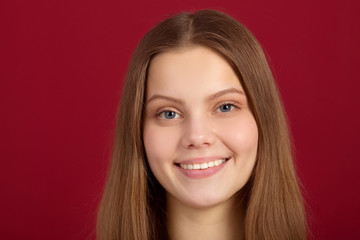 beautiful young woman with her hair on a red background