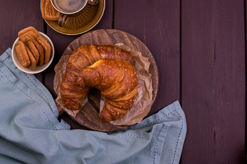 croissant and coffee. Fresh italian pastries and aromatic coffee on a wooden table . Beautiful food postcard.